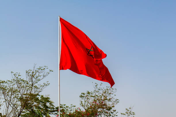 istock Isolated Moroccan flag with green star waving in a blue sky 1409184114