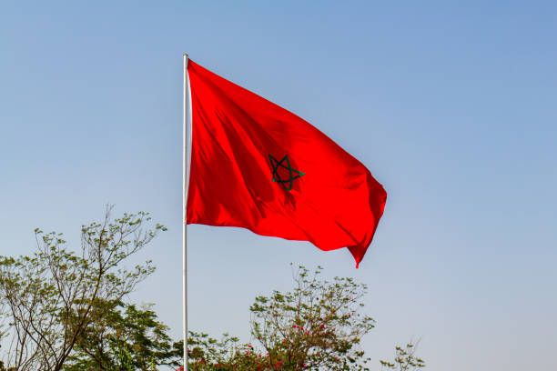 istock Isolated Moroccan flag with green star waving in a blue sky 1409184221