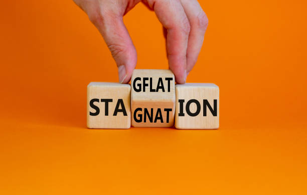 istock Stagflation or stagnation symbol. Businessman turns cubes, changes the word stagnation to stagflation. Beautiful orange background, copy space. Business, stagflation or stagnation concept. 1409185389