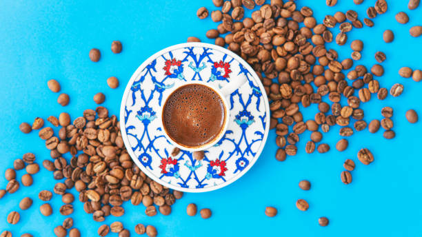 istock Coffee beans and coffee cup on blue background 1409190522