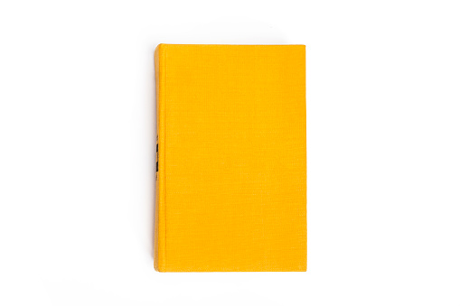Yellow closed book with blank cover on white background