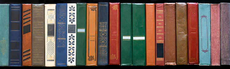 Vintage books in row. Different hardcover books background. Literature, reading concept. Book texture