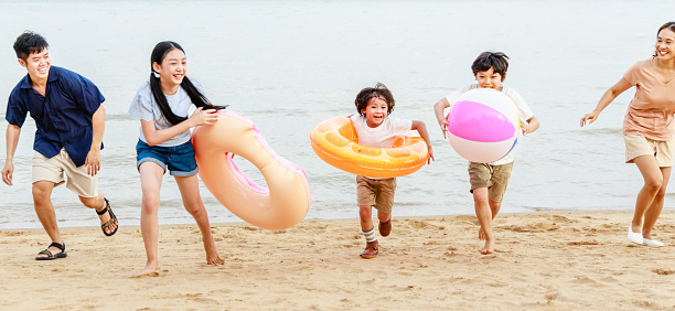 Happy kids having fun with beach ball together in a summer holiday. Recreation, leisure activities