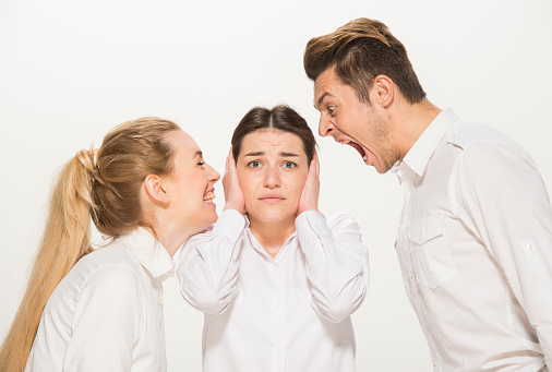 team of young business people in white shirts on a white background isolated. a team of two girls and a guy is happy, wins, plans, argues, discusses, gets upset, wins something. close-up portrait of a group of people in white clothes.