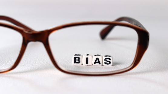 Business concept with white cube arranged in the word  ’BIAS' and glasses.