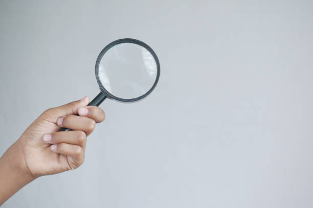 istock hand holding magnifying glass against white 1409200238