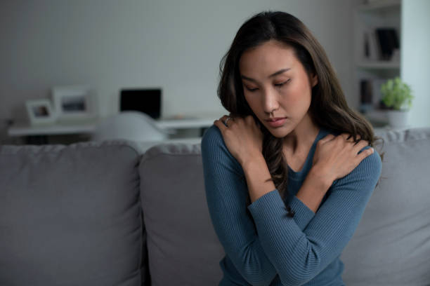 istock Woman sitting on couch at home feeling sad, life difficulties. 1409200990