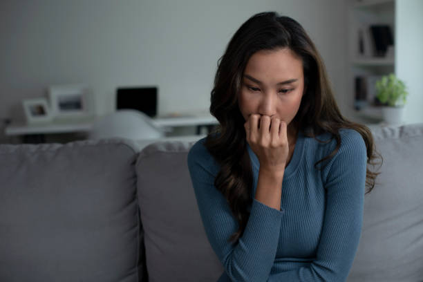 istock Woman sitting on couch at home feeling sad, life difficulties. 1409200991