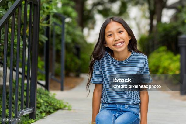 Portrait Of A Young Asian Girl Smiling Outside Stock Photo - Download Image Now - Child, Happiness, Girls
