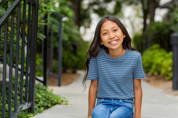 portrait of a young asian girl smiling outside. - carefree joy children only pre adolescent child imagens e fotografias de stock