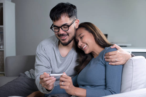 couple joyeux découvrant les résultats d’un test de grossesse à la maison. concept de famille heureuse. - pregnancy test human pregnancy medical test human fertility photos et images de collection