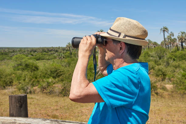 istock Latin senior man looking through binoculars, El Palmar National Park, Argentina 1409207605