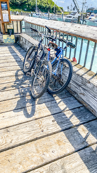 A two bikes stand at the ready. Sitting at the pier, these bikes are ready for adventure or to help get around at the docks.