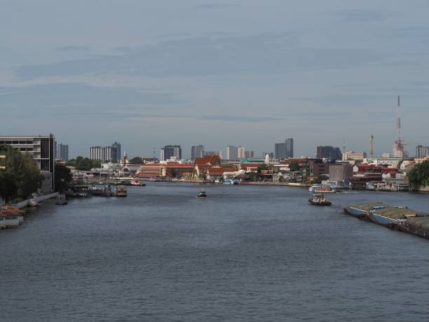 istock Silver gray river, buildings, roofs, silver turquoise sky, white clouds, gray portesses. 1409218295