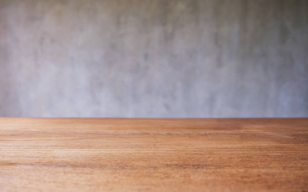 istock Wooden table top with blurred of concrete wall background 1409218631