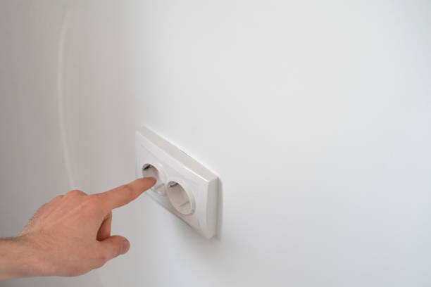 istock person's finger touching the electricity socket at home 1409218871