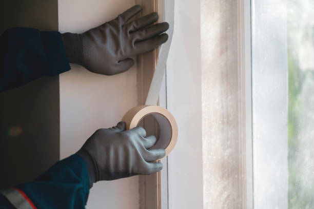 istock paint worker put masking tape on the wall 1409219466