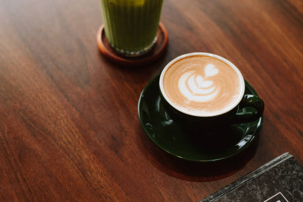 Freshly made Espresso and Latte and Green tea with notebook on a woody table on coffee shop