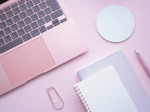 istock A cute PC desk image taken from a bird's-eye view with a laptop, notebook and notebook side by side on a solid pink background 1409231311