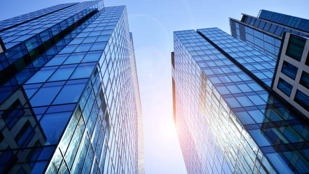 istock Bottom view of modern skyscraper in business district against blue sky. 1409232152
