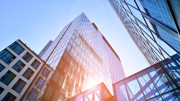 istock Bottom view of modern skyscraper in business district against blue sky. 1409232179