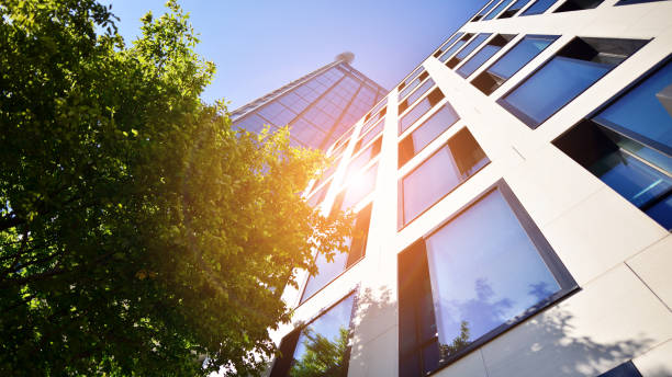istock Bottom view of modern skyscraper in business district against blue sky. 1409232404