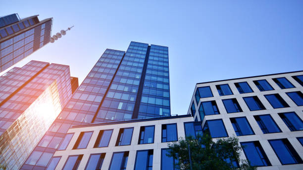 istock Bottom view of modern skyscraper in business district against blue sky. 1409233060