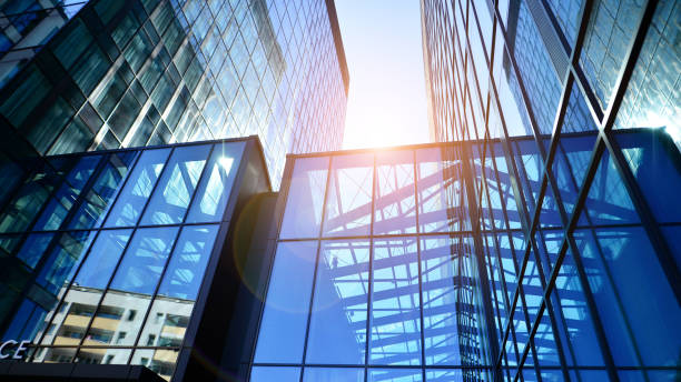 istock Bottom view of modern skyscraper in business district against blue sky. 1409233317