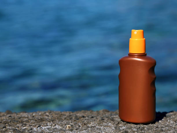 istock Sunscreen spray bottle on the stone shore with blue sea water background with copy space 1409238426