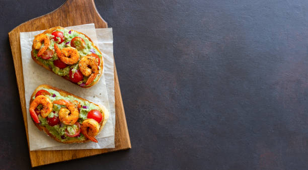 bruschetta con gamberi, guacamole e pomodori. mangiare sano. colazione. - sandwich avocado prepared shrimp bread foto e immagini stock