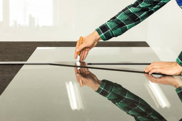 istock glazier cuts a mirror in a factory, glass industry, manual work 1409247248