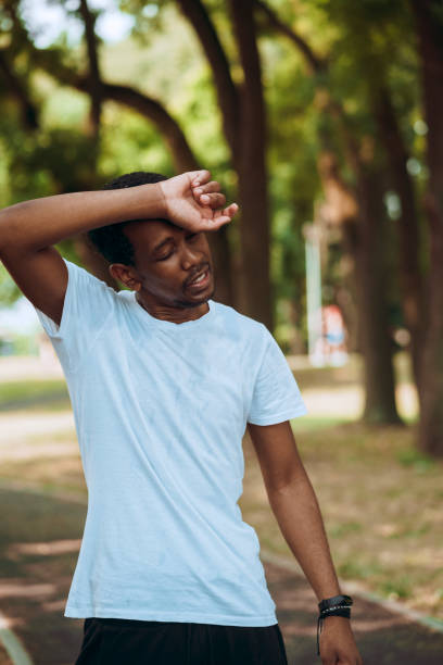 istock Young man working out at public park on hot sunny morning 1409247412