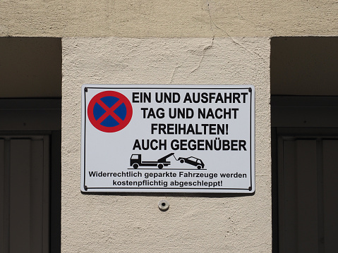 German no parking sign Ein und Ausfahrt Tag und Nacht freihailten auch gegenueber translation Keep entrance and exit free day and night, also opposite