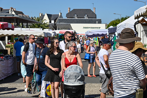 Erquy, Brittany, France, July 9, 2022 - People on the weekly summer market of local producers and craftsmen in Erquy, Brittany