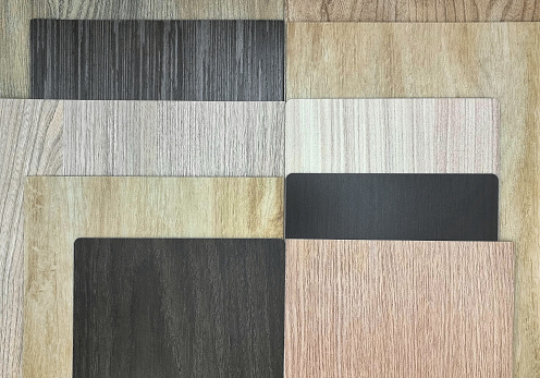 various types and textures of interior wooden material including walnut veneer, ash laminated, oak vinyl flooring samples. multi texture of wood use as background. Production of wooden materials.