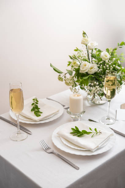 istock Wedding table decoration with white flowers, glasses and white napkins. Elegantly decorated table at a wedding reception. Festive table setting. The wedding decor. 1409253712