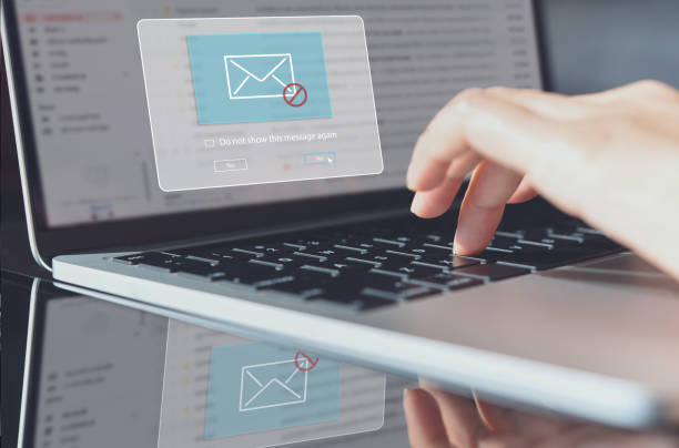 istock Blocking spam e-mail, warning pop-up for phishing mail, network security concept. Business woman working on laptop computer at home with warning window 1409254657