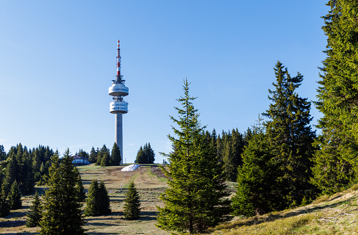The high tourist observation tower Snezhana on the mountain peak of Snezhana covered with evergreen spruce dense forests in the Rhodope mountains and hills