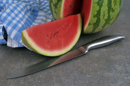 Slice of watermelon with a knife close-up