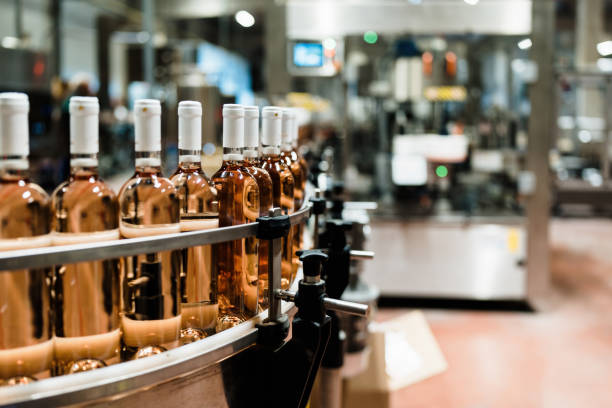 Industrial wine bottling production line Industrial wine bottling plant theme. Modern industry production line for alcohol drink bottling and packaging. vinification stock pictures, royalty-free photos & images