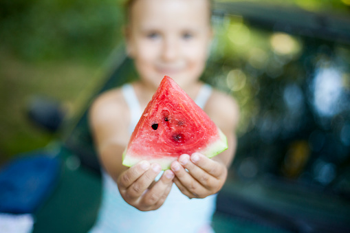 girl eating watermelon outdoors
