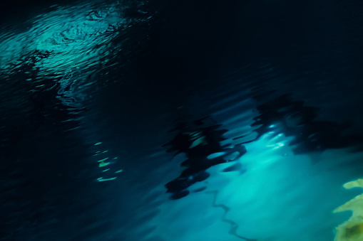 Divers underwater on a night dive. Abstraction, defocus