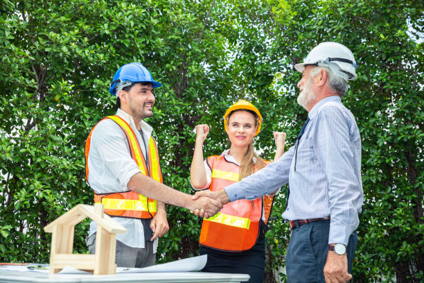 istock Professional construction engineers in uniform with helmet are making a deal with architect discussing about their architecture project of modern house building. Construction and structure concepts. 1409262436