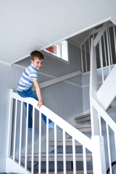 istock Boy sliding on the staircase in the house 1409263810