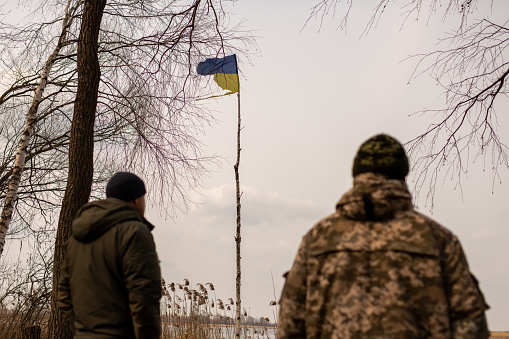 Photo on theme of large Ukrainian flag made from birch trunk develops in cloudy sky during war