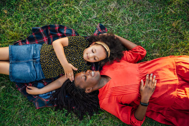 istock Happy mother and daughter lying on the grass 1409269850