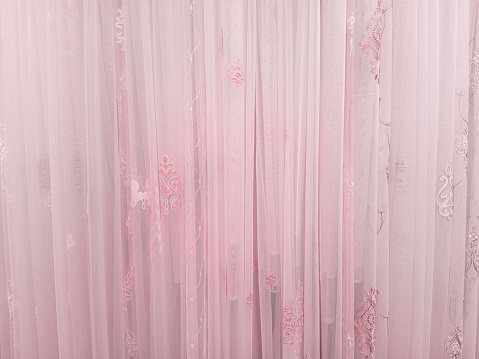 Pink tulle curtains with  pattern. Background texture.