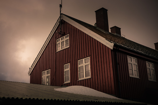 A Norwegian townhouse under a moody cloudy sky