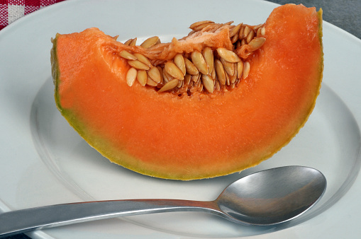Slice of sliced melon in a plate with a spoon