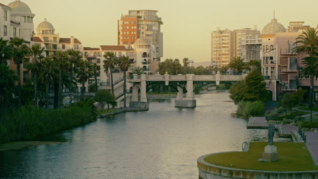 Beautiful canal walk bridge and clear sky with copy space. An artificial river way surrounded by city commercial buildings at a popular tourism destination. An empty waterway in Century City district